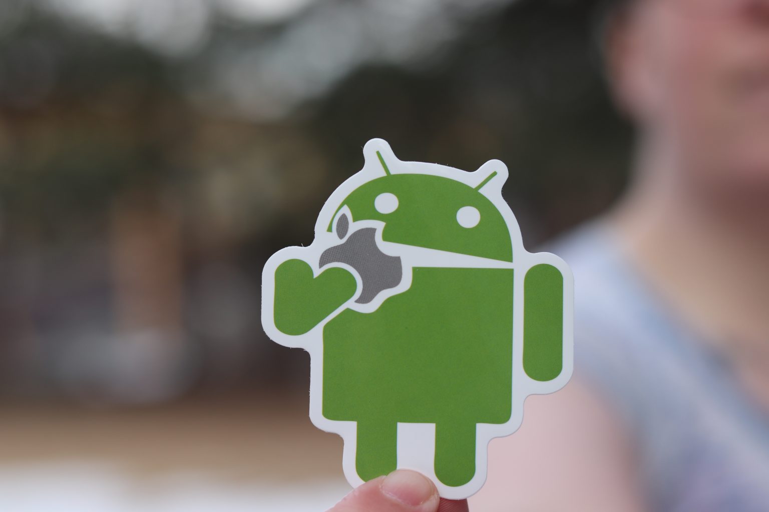 Android logo and allple logo in the hand of it